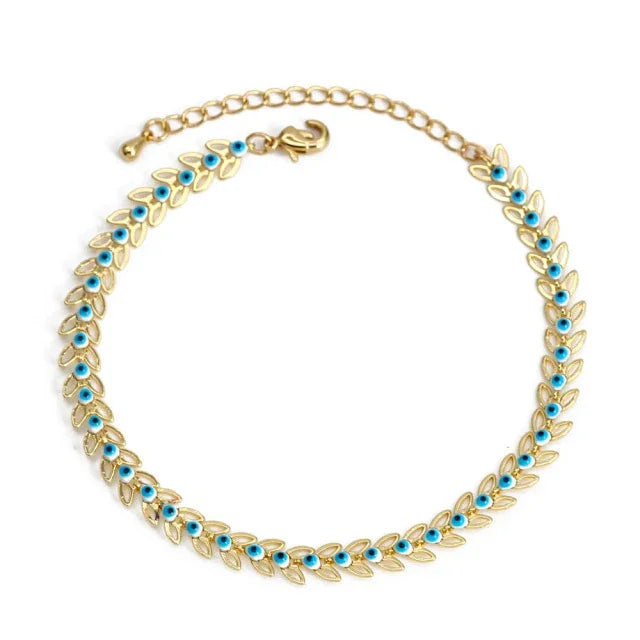 Gold leaf bracelet with blue gemstone accents and adjustable chain on white background