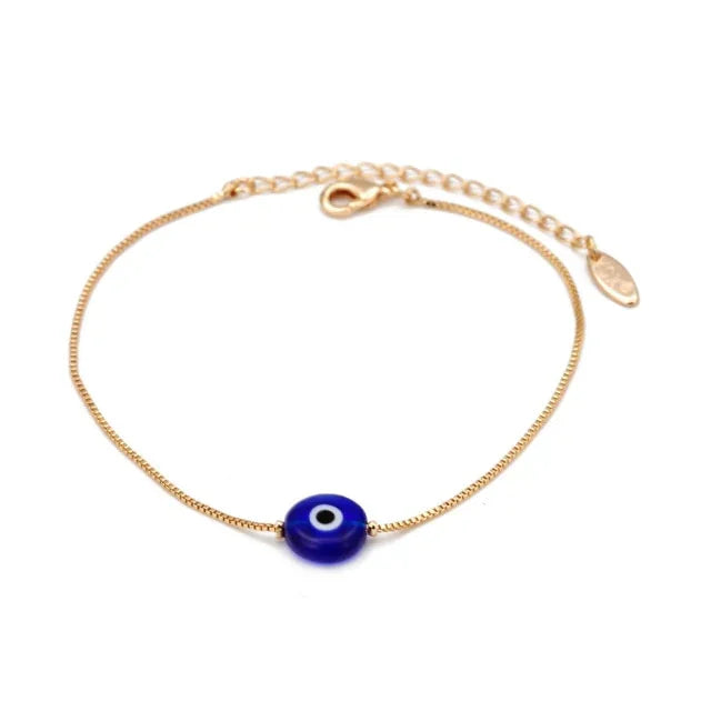 Gold chain bracelet with blue evil eye charm and adjustable clasp on white background