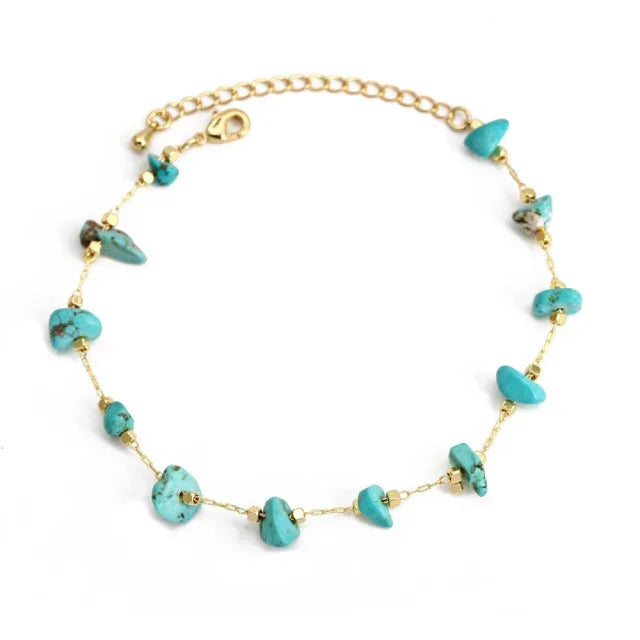 Gold chain bracelet with turquoise stone beads on white background